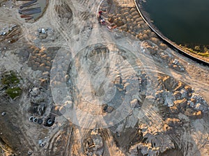 Aerial view of three multi-colored dump tip trucks unloading in