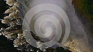 Aerial view in the throat of Victoria Falls with ground visible through the spray at the end of rainy season from helicopter.