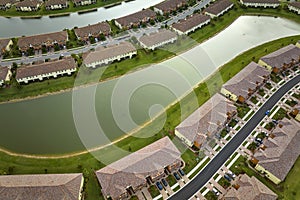Aerial view of tightly located family houses with retention ponds to prevent flooding in Florida closed suburban area