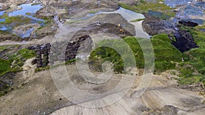 Aerial view on tiny dump truck and bulldozer in sand quarry