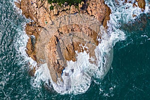 Aerial view of tiny rocky island in sea