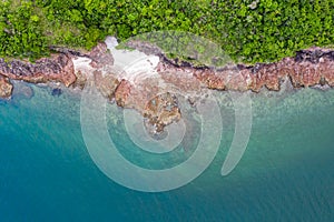 Aerial view of tiny rocky island in sea