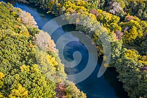 Aerial view to autumn forest with river bend, natural colorful background