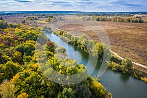 Aerial view to autumn forest with river bend, natural colorful background