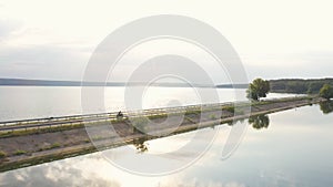 Aerial view to biker riding on motorbike at dam route with sunshine at background. Motorcyclist racing his motorcycle