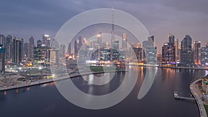 Aerial view to Dubai Business Bay and Downtown with the various skyscrapers and towers day to night timelapse