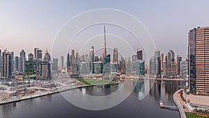 Aerial view to Dubai Business Bay and Downtown with the various skyscrapers and towers day to night timelapse