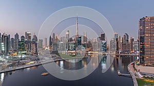 Aerial view to Dubai Business Bay and Downtown with the various skyscrapers and towers day to night timelapse