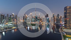 Aerial view to Dubai Business Bay and Downtown with the various skyscrapers and towers day to night timelapse