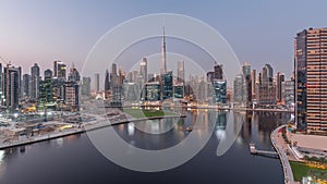 Aerial view to Dubai Business Bay and Downtown with the various skyscrapers and towers day to night timelapse