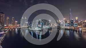 Aerial view to Dubai Business Bay and Downtown with the various skyscrapers and towers night timelapse