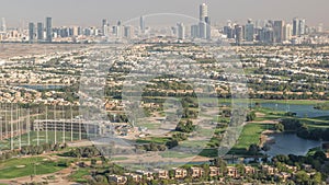 Aerial view to Golf course with green lawn and lakes, villa houses behind it timelapse.