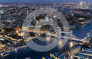 Aerial view to the illuminated skyline of London, UK, during evening time with Tower bridge