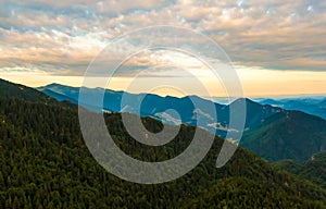 Aerial view to Mala Fatra mountains in Slovakia. Sunrise above mountain peaks and hills in far. Beautiful nature, vibrant colors.