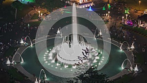 Aerial view to Park of the Reserve with colorful magic water circuit biggest fountain complex night timelapse