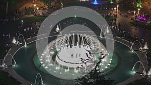 Aerial view to Park of the Reserve with colorful magic water circuit biggest fountain complex night timelapse