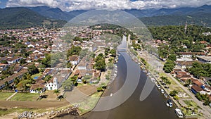 Aerial view to river Pereque-Acu in historic town Paraty with green mountains covered with white clouds in background, Unesco