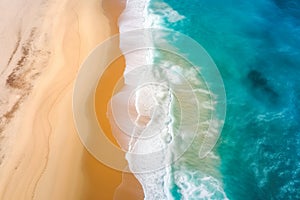 Aerial view to tropical sandy beach and blue ocean. Top view of ocean waves reaching shore on sunny day.