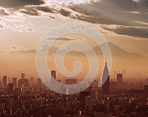 Aerial view of Tokyo at sunset, with the silhouette of Mount Fuji