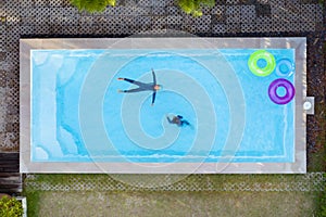 Aerial view or top view of children are swimming in swimming pool