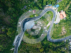 Aerial view top down drone shot above the winding mountain road between the trees rainforest,Phuket Thailand,in summer season