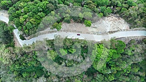 Aerial view top down drone shot above the winding mountain road between the trees rainforest,Phuket Thailand,in summer season weat