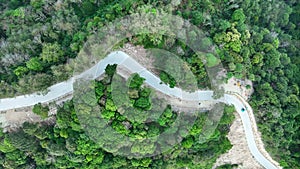 Aerial view top down drone shot above the winding mountain road between the trees rainforest,Phuket Thailand,in summer season weat