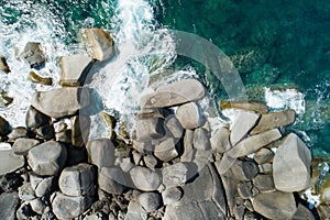 Aerial view Top down seashore big wave crashing on rock cliff Beautiful dark sea surface in sunny day summer background Amazing