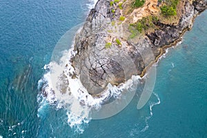 Aerial view Top down seashore big wave crashing on rock cliff Beautiful dark sea surface in sunny day summer background Amazing