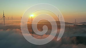 Aerial view top hill at dawn with fog covering small village in valley