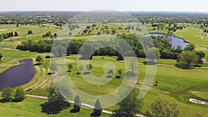 Aerial View from the top n of the golf course. People and cars on a golf course from a height.