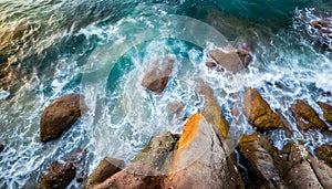 Aerial view top seashore, rocky coast, waves crashing on rock cliff. Blue ocean surface sunny summer