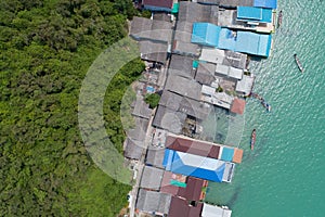 Aerial view top view of the fisherman village with fishing boats and house roof at the pier in koh rat suratthani Thailand