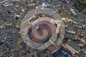 Aerial view of Torre del Mangia with city skyline at sunset, a famous landmark in Piazza del Campo, Siena, Tuscany, Italy
