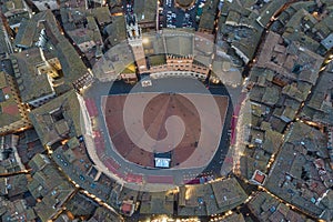 Aerial view of Torre del Mangia with city skyline at sunset, a famous landmark in Piazza del Campo, Siena, Tuscany, Italy