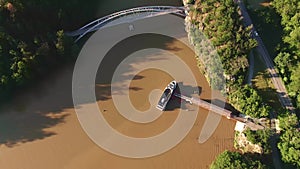 Aerial view of tourist boat on the river. Tourists are boarding to boat which continue to next stop near bay. Mud river, green tre