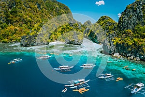 Aerial view of tourist boats in front of big Lagoon at Miniloc Island, El Nido, Palawan, Philippines. Surreal karst photo