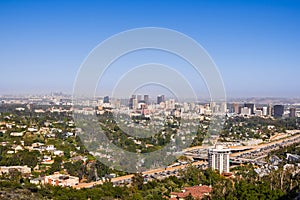 Aerial view towards the skyline of Century City commercial district; downtown area skyscrapers visible in the background; highway