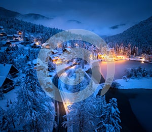 Aerial view of town in snow, road, forest, lake and houses