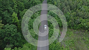 aerial view tracking after car moving by speedway green forest by both side