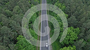 aerial view tracking after car moving by speedway green forest by both side