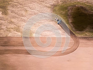 Aerial view of the tractor in the field, agricultural field work. Tractor cultivating field, aerial view