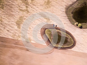 Aerial view of the tractor in the field, agricultural field work. Tractor cultivating field, aerial view