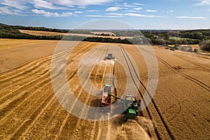 Aerial view of a tractor and harvester working in a field. Agriculture and cultivation of industrial farms. Agribusiness