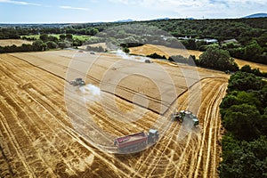 Aerial view of a tractor and harvester working in a field. Agriculture and cultivation of industrial farms. Agribusiness