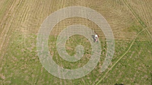 Aerial view of tractor with hay in the field. Bales of hay stacked in the trailer. Agricultural work. The concept of