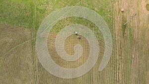Aerial view of tractor with hay in the field. Bales of hay stacked in the trailer. Agricultural work. The concept of