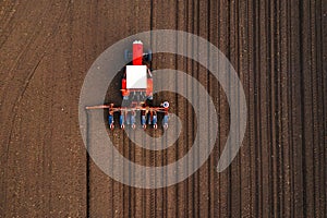 Aerial view of tractor with mounted seeder performing direct seeding