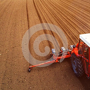 Aerial view of tractor with mounted seeder performing direct seeding