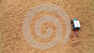 Aerial view of Tractor mowing agricultural farm grass field